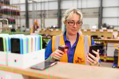 SK tes employee scans mobile phone demonstrating asset registration