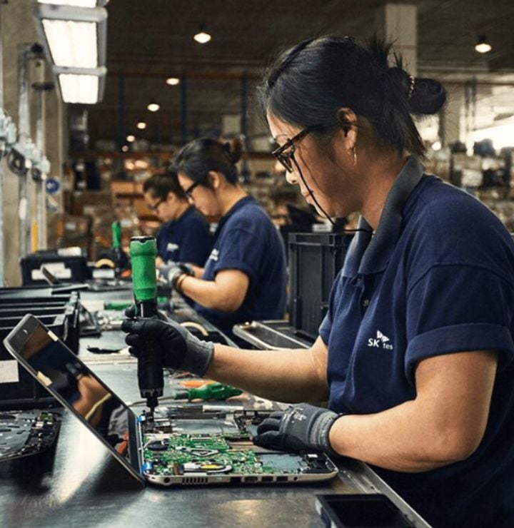 SK Tes employee pulling spare parts from laptop - e waste recycling services