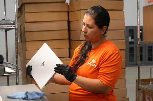SK tes Team Member Inspects Laptop