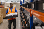 Operator stacks shelves with refurbished mobile phones ready for resale or redeployment