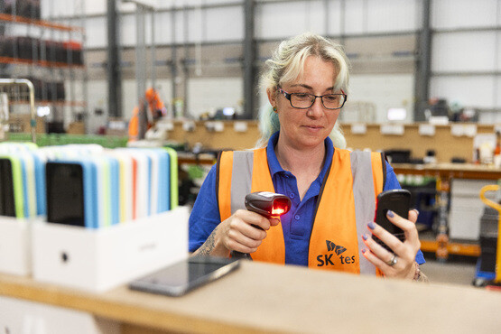 SK tes employee scans mobile phone demonstrating asset registration